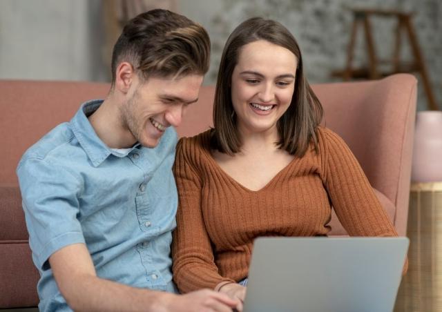 年轻夫妇看着他们的笔记本电脑.